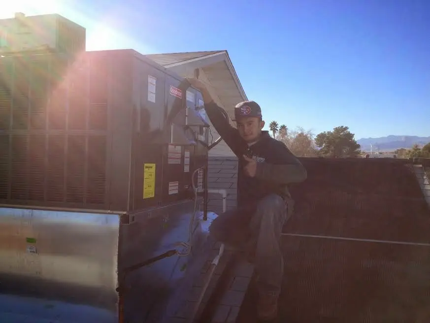 HVAC technician performing AC Tune-Up on a rooftop unit in Elmwood